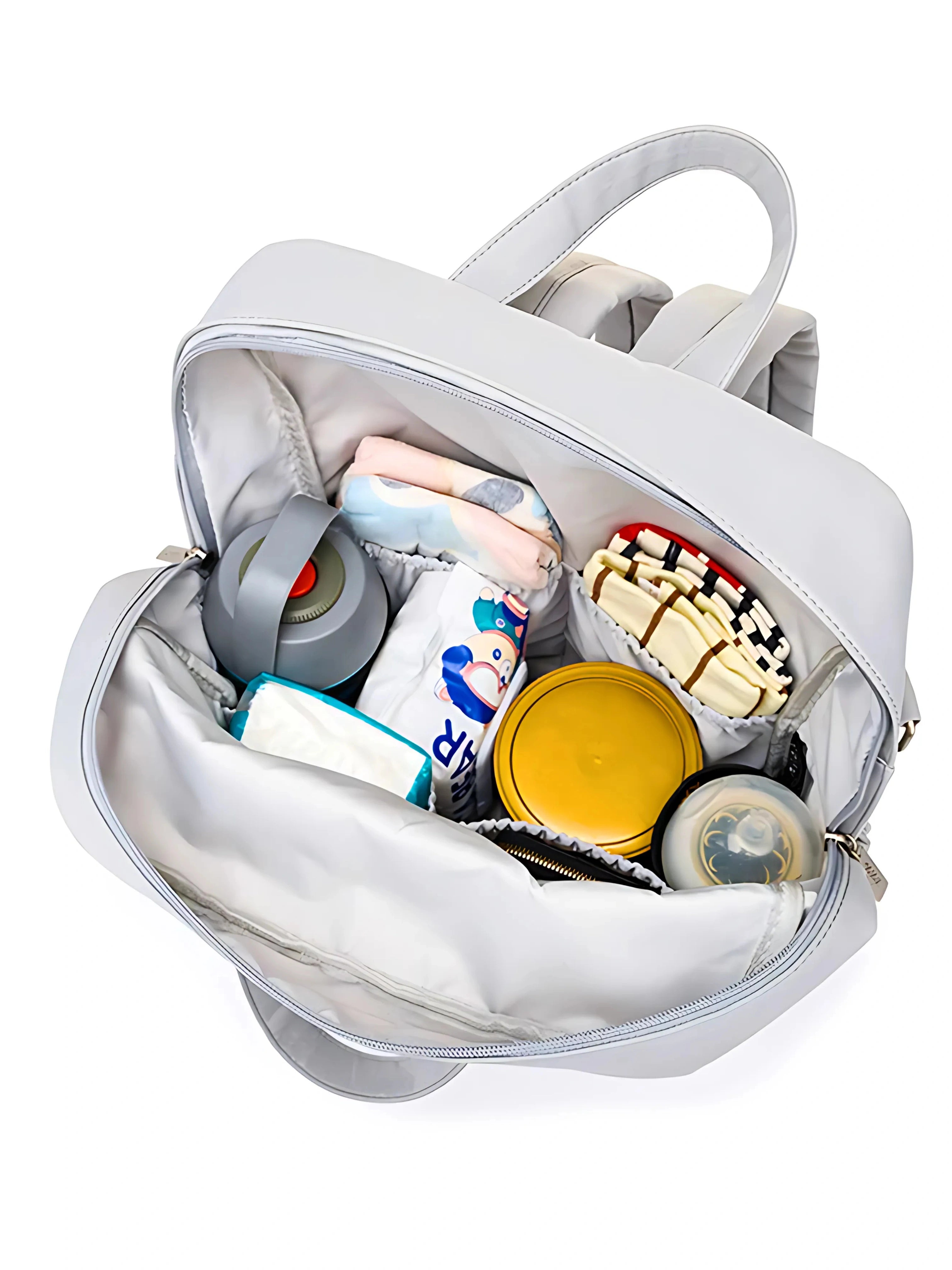 Vue intérieure d’un sac à langer gris avec plusieurs compartiments organisés pour ranger biberons, couches et accessoires pour bébé.