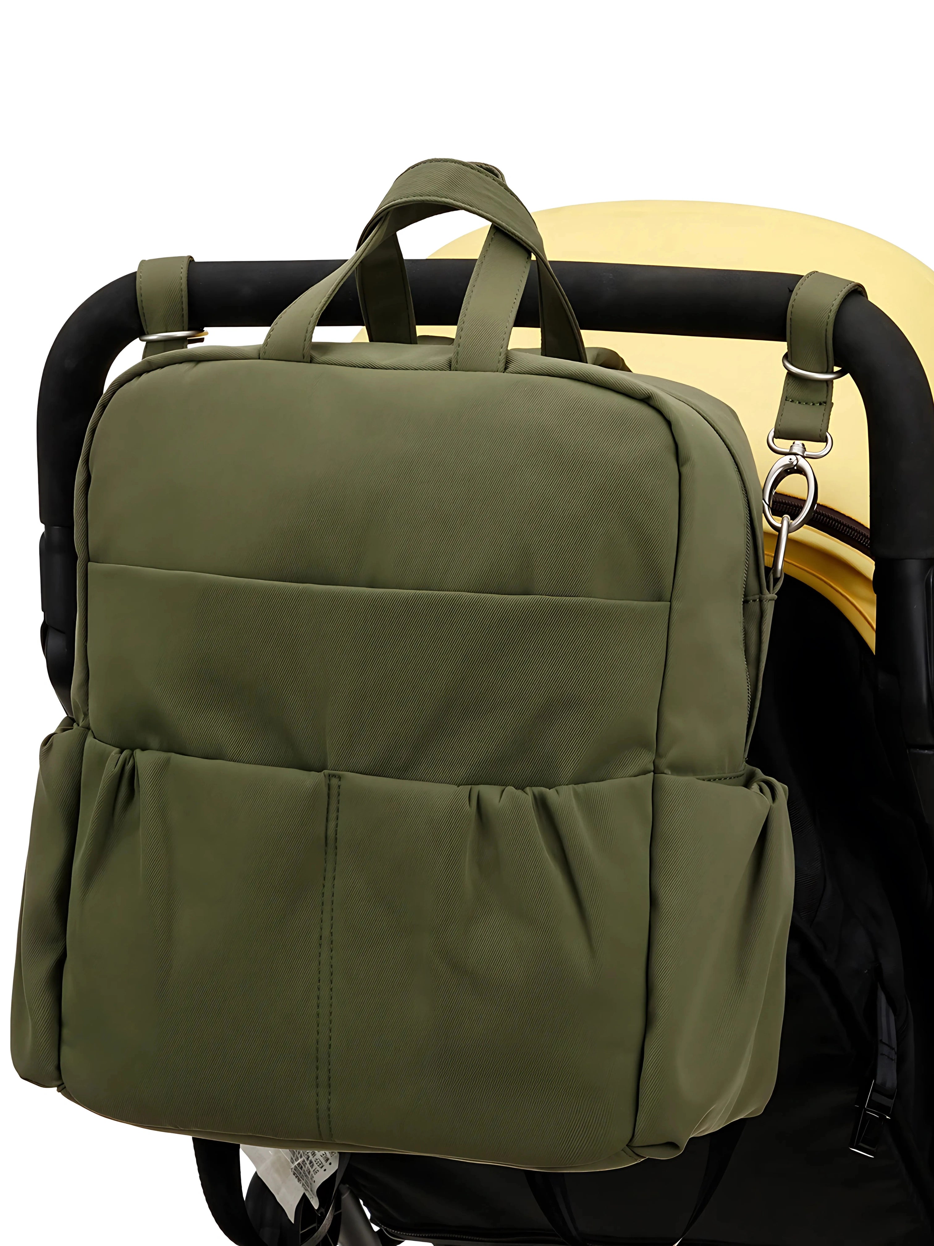 Sac à langer vert multifonction attaché à une poussette, avec plusieurs poches pratiques pour organiser les affaires de bébé.