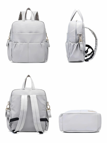 Vue complète d’un sac à langer gris multifonction, avec plusieurs poches et bretelles réglables, idéal pour les parents en déplacement.