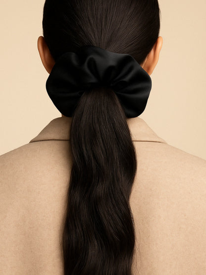 Chouchou cheveux noir en satin, accessoire chic et minimaliste pour sublimer toutes vos coiffures.