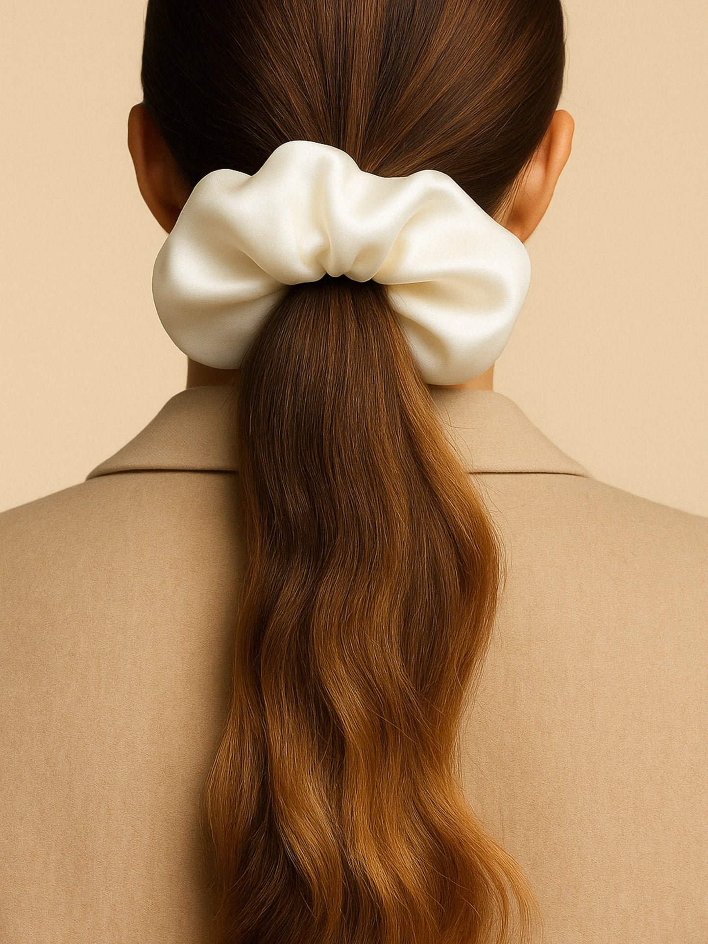 Chouchou cheveux en satin blanc porté sur queue de cheval, accessoire élégant et tendance pour femme.
