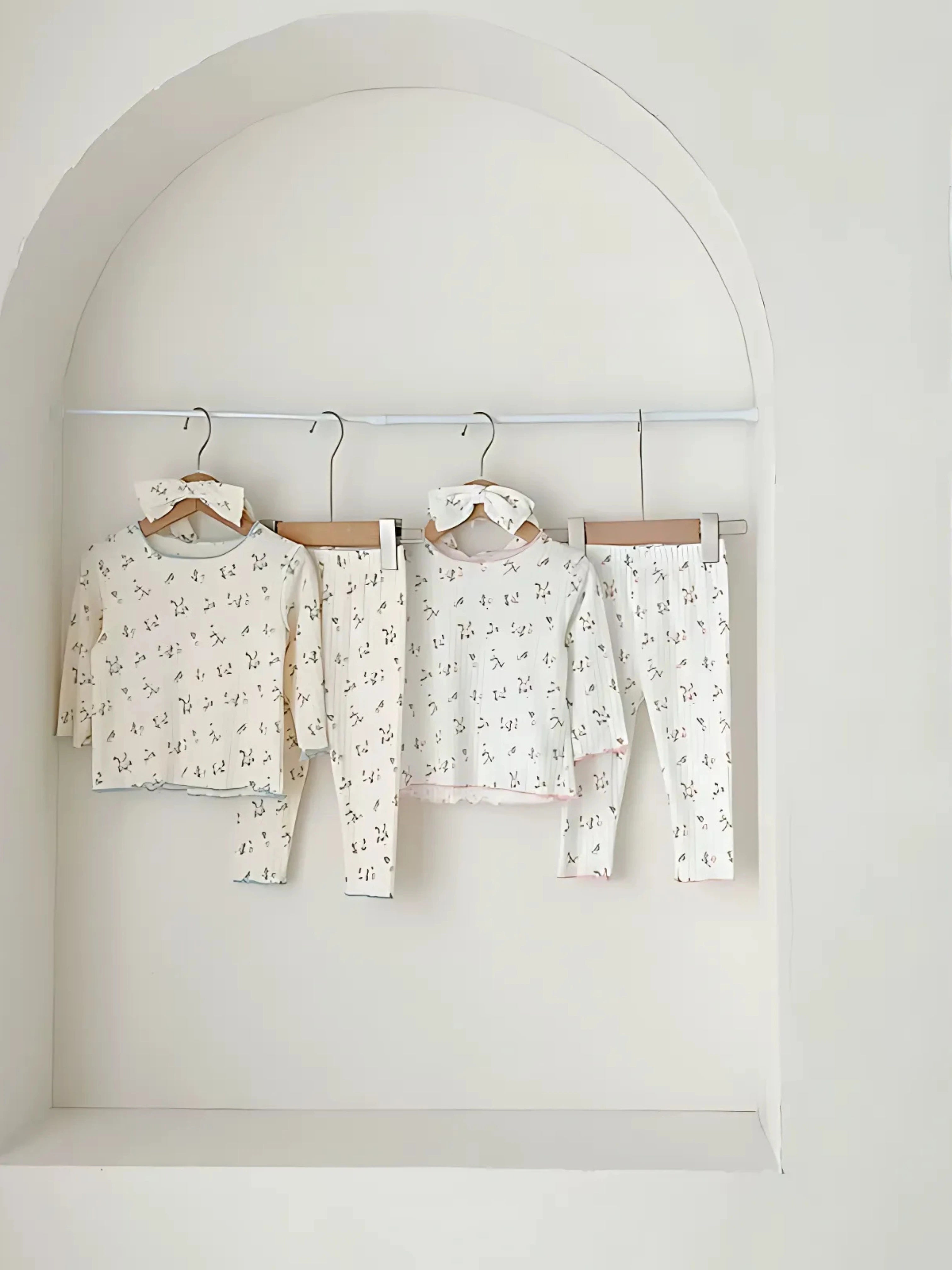 Ensemble pyjama bébé mixte avec imprimé délicat suspendu dans une arcade, parfait pour des nuits douces et confortables.