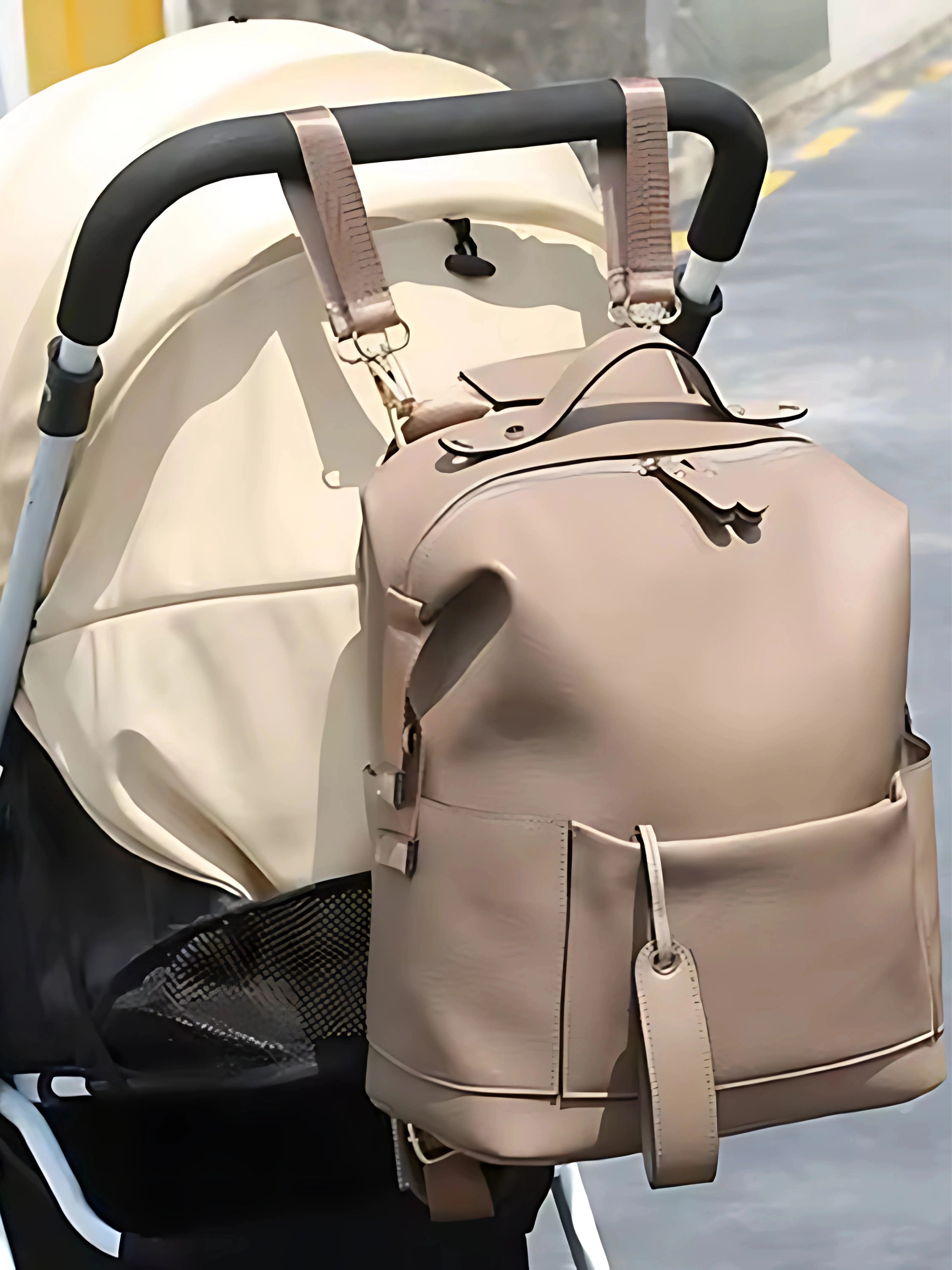 Sac à langer beige attaché à une poussette, design élégant et pratique pour les déplacements avec bébé.