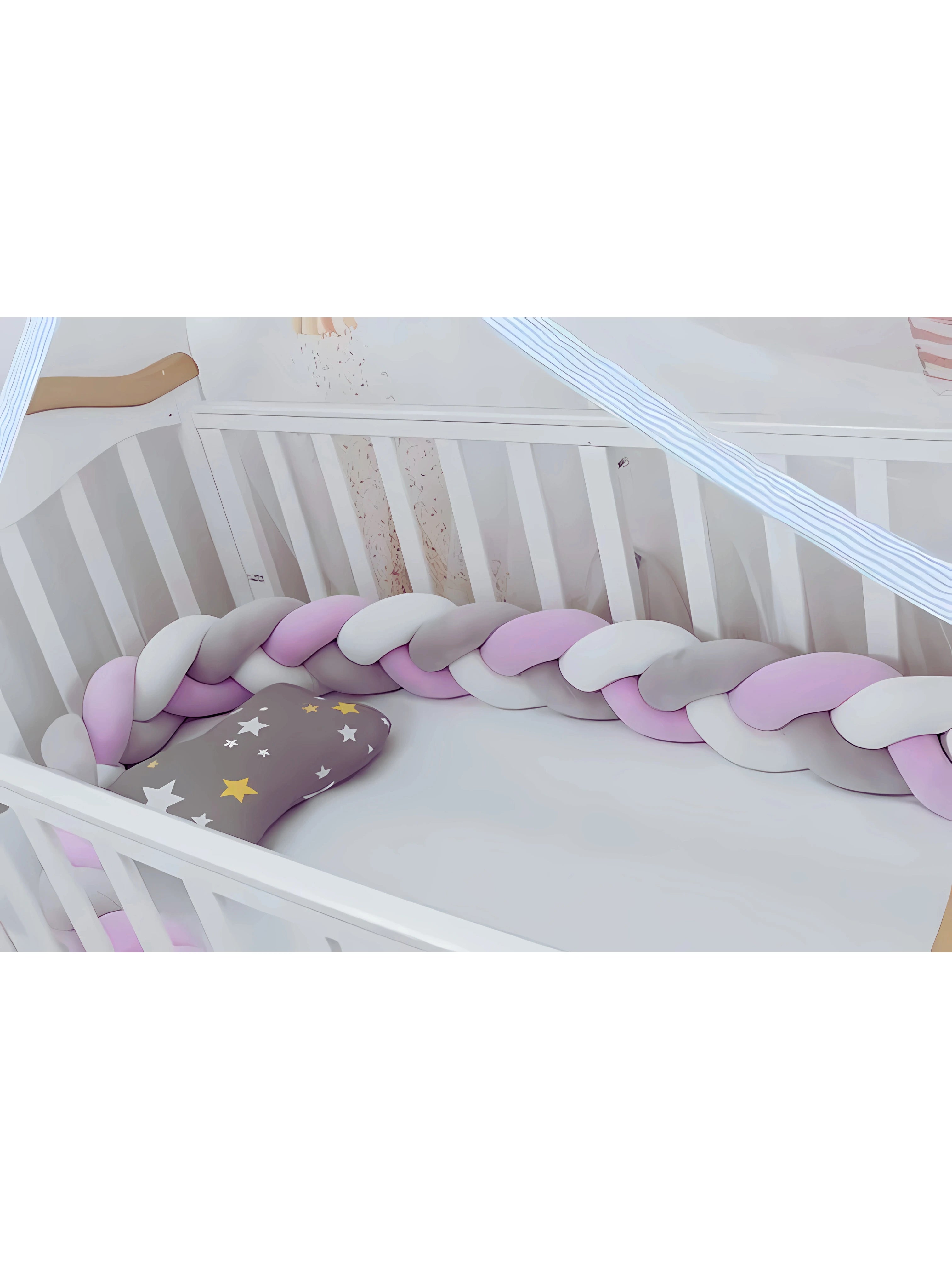 Tour de lit tressé rose, gris et blanc installé dans un berceau, protégeant bébé avec douceur.